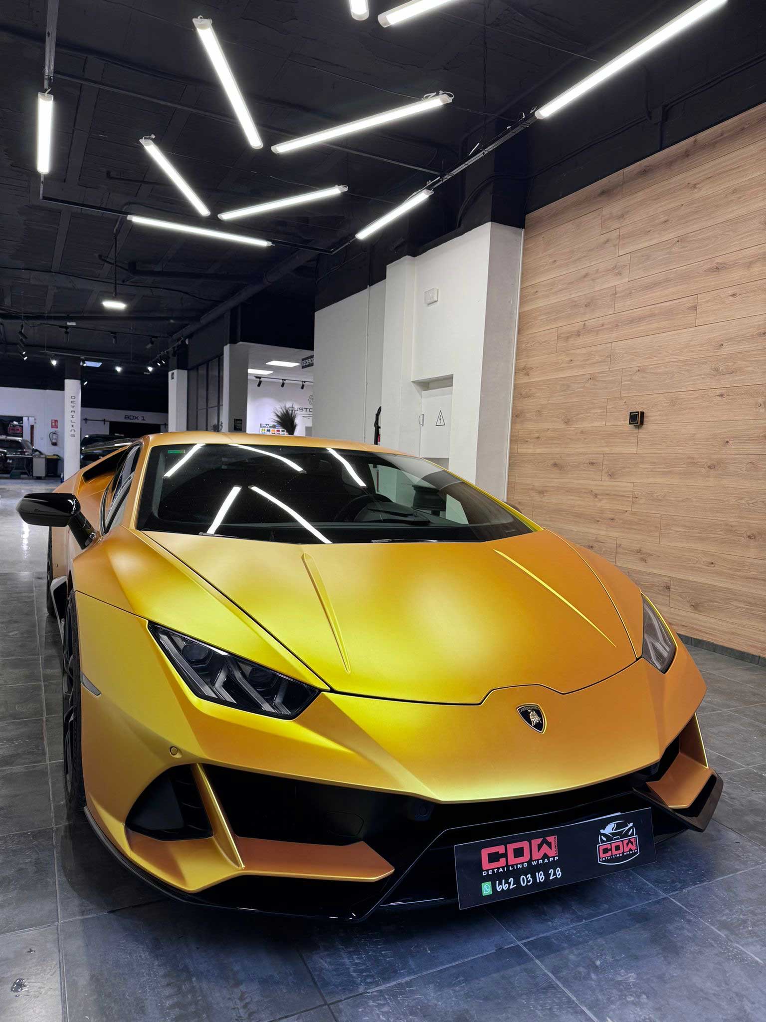 Lamborghini Huracán envuelto en vinilo oro satinado en el taller CDW Llacer, con detalles en negro y acabado de fábrica.