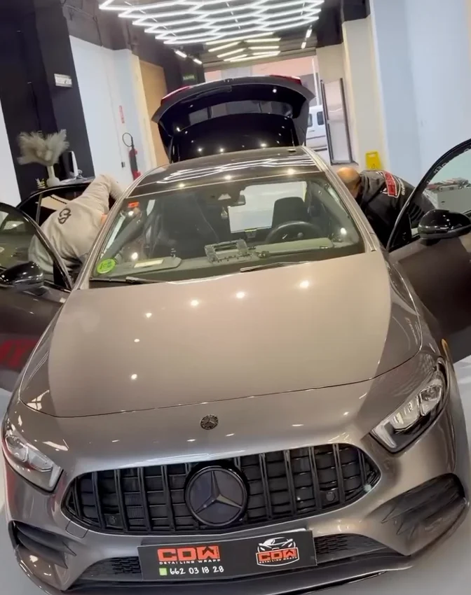 Mercedes gris en taller de detailing y wrapping con puertas y portón abiertos